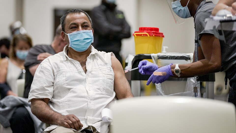 Un homme se fait vacciner.