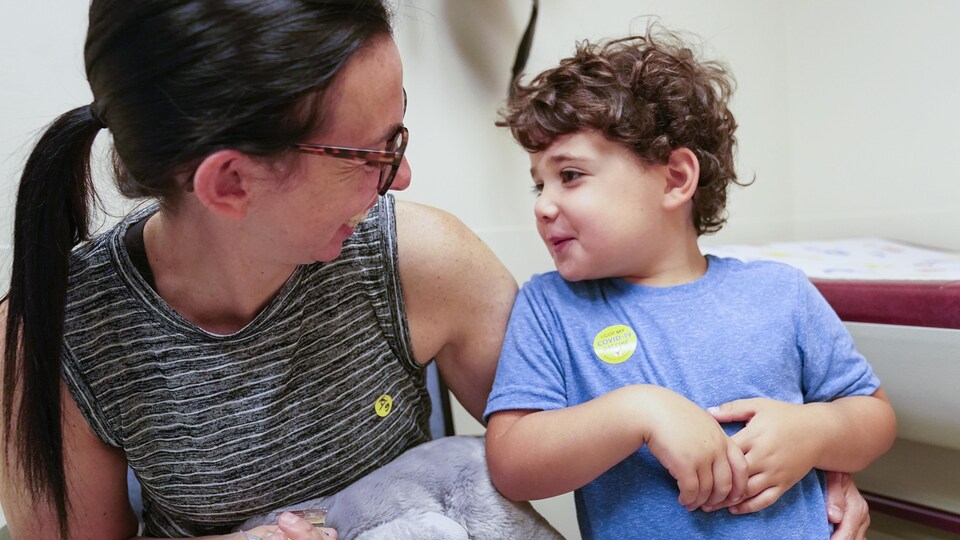 Une mère sourit à son jeune fils qui vient d'être vacciné contre la COVID-19.