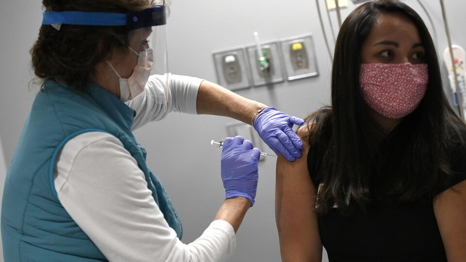 Vail Health Hospital employee health nurse Diane Schmidt, left, gives a mock COVID-19 vaccine to Caitlyn Ngam, right, an infection preventionist at the hospital, Tuesday, Dec. 8, 2020 in Vail, Colo. With the state expecting its first shipment of a COVID-19 vaccine in a matter of days, the state health department ran an exercise to see how ready it is to take on such a mass vaccination campaign. The Pfizer vaccine, which is the first shot expected to gain federal approval, will be difficult for