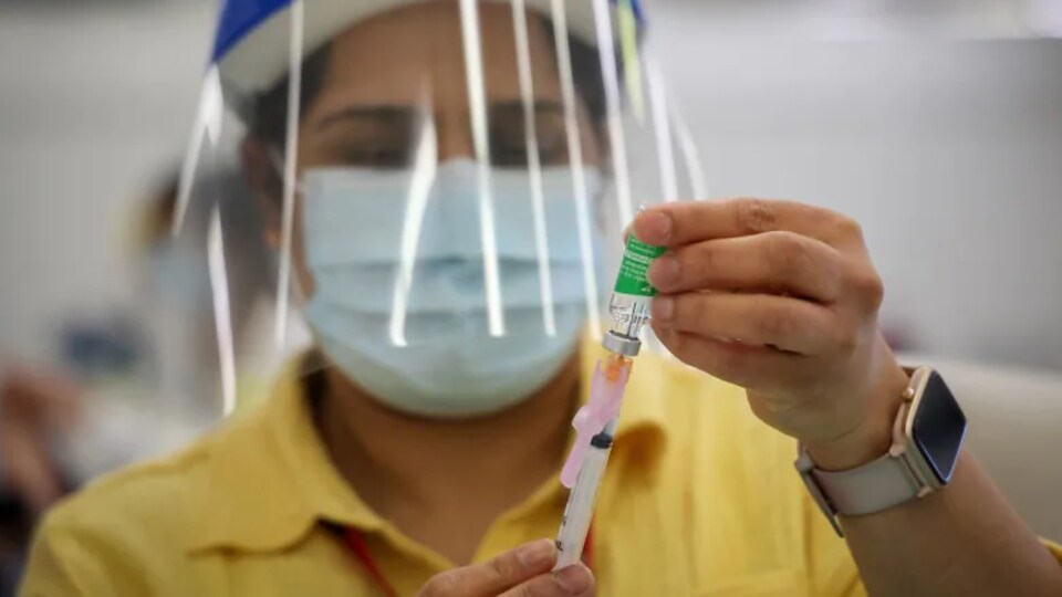 Un travailleur en santé prépare une dose de vaccin.