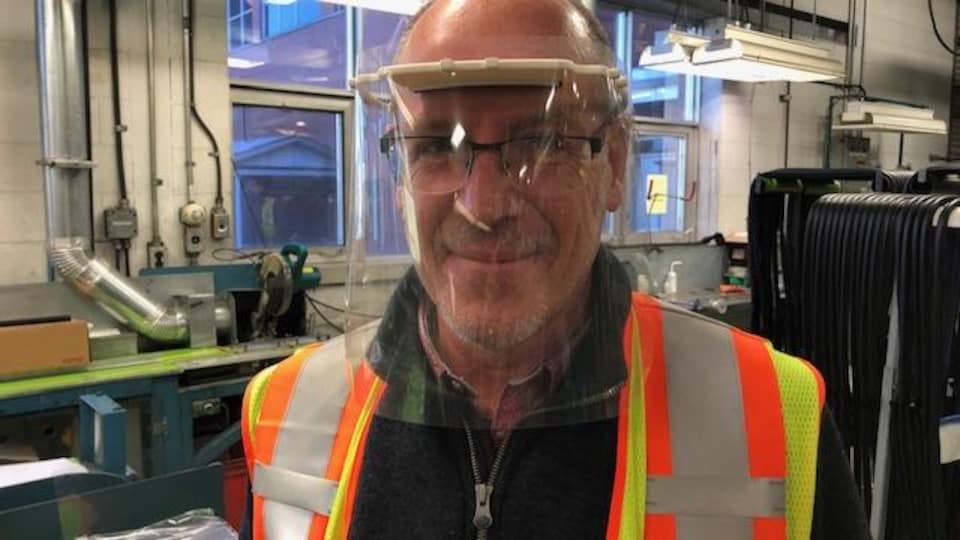 Un employé Waterville TG porte une visière de protection à l'intérieur de l'usine