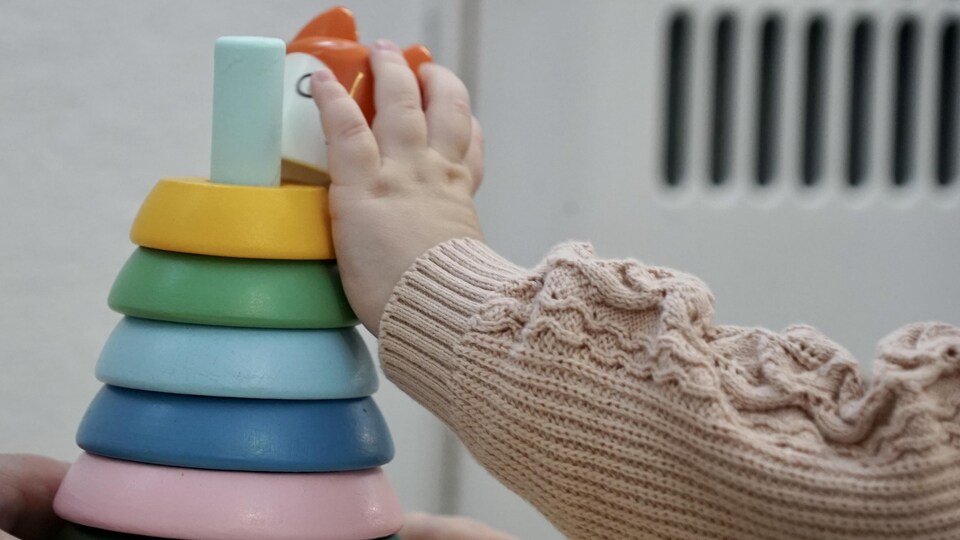 La main d'un enfant en bas âge sur un jouet