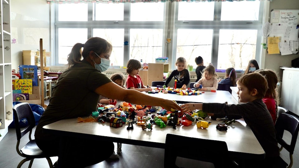 Des enfants s'amusent avec des jouets en compagnie de leur éducatrice, dans un centre de la petite enfance.                          
