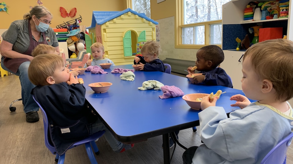 Des enfants qui mangent à une table dans un CPE.