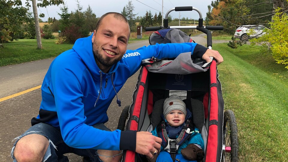 Un homme avec un bébé dans une poussette