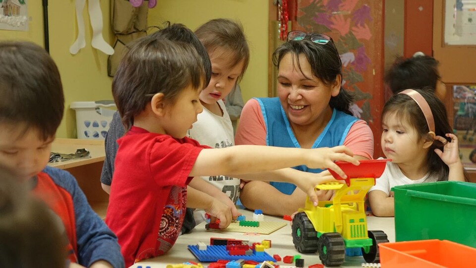 Une éducatrice du CPE Sakahitokiwam, à Obedjiwan, en Haute-Mauricie, amuse les enfants de son groupe.