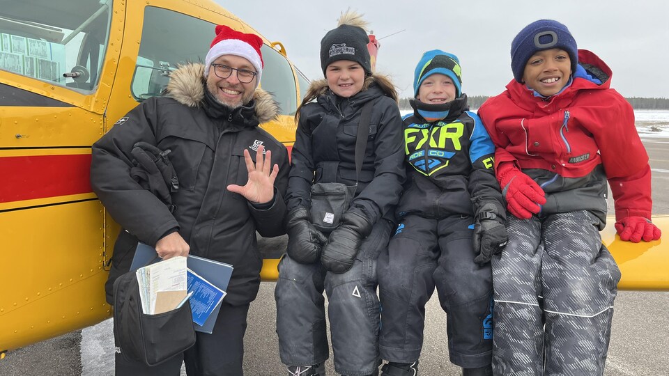 Des jeunes sont assis sur une aile d'avion.