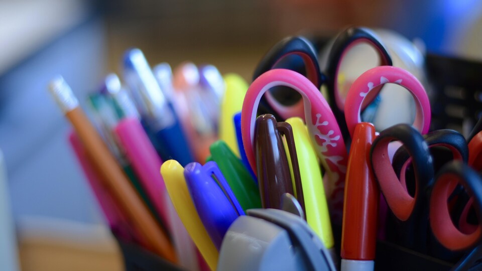 Plan rapproché de crayons et ciseaux se trouvant dans un porte-crayon.
