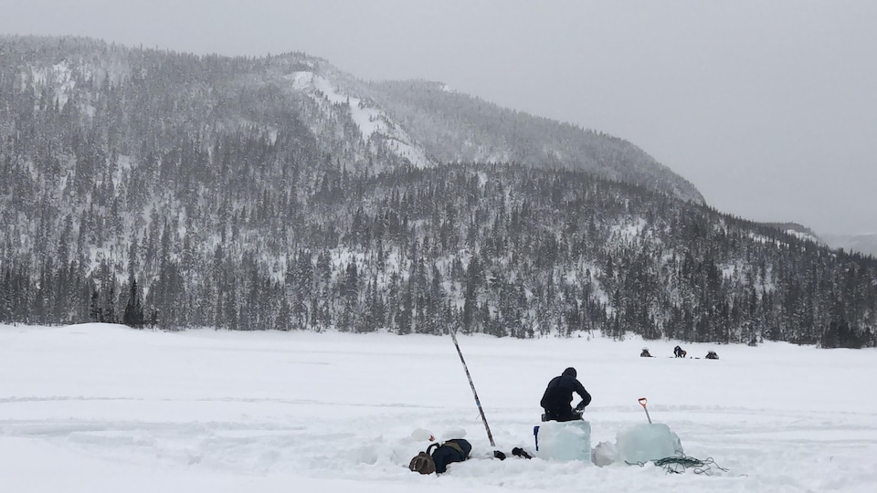 Un biologiste travaille sur la glace d'un lac gaspésien. 
