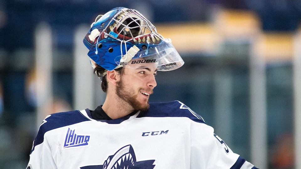 Un joueur de l'Océanic a son casque de hockey relevé sur le bout de sa tête.
