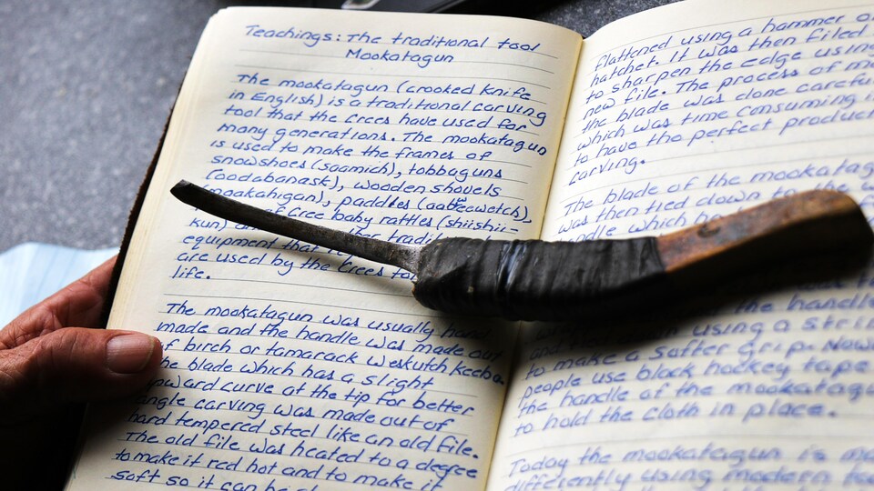 Un cahier avec dessus un couteau traditionnel.