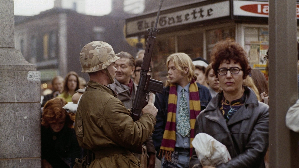 Un soldat monte la garde à une intersection du centre-ville de Montréal lors de l'entrée en vigueur de la Loi sur les mesures de guerre, en octobre 1970 