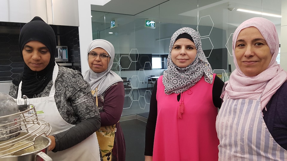 Quatre femmes sont à l’œuvre dans une cuisine communautaire.