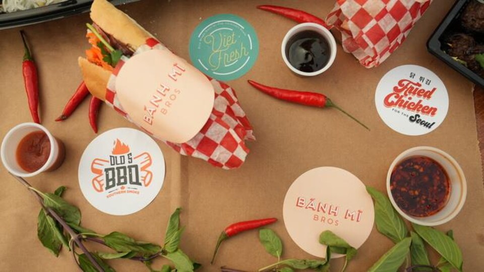Des sous-verres à l'effigie de différentes marques de restauration sont disposés sur une table décorée avec des piments forts.