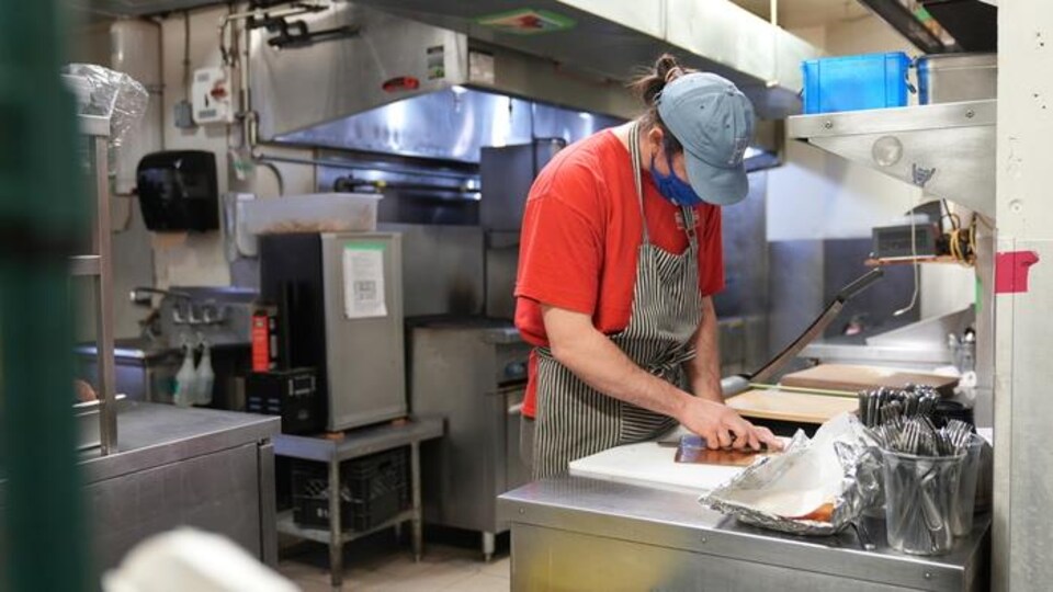 Un cuisinier dans une cuisine de restaurant.