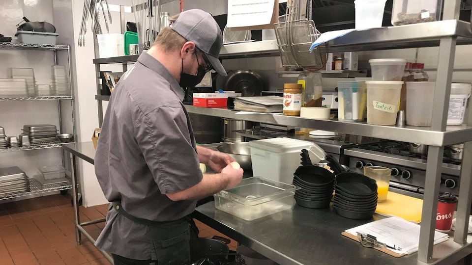 Un homme travaille en cuisine.