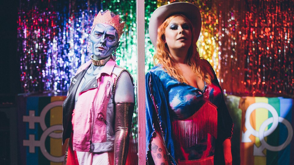 Deux artistes drags dos à dos et regardant l'objectif.