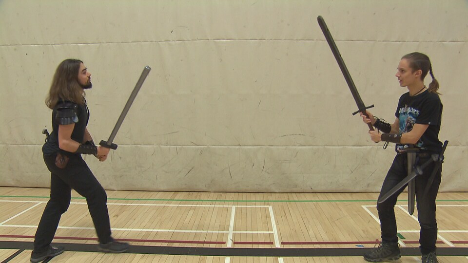 deux adolescents simulent un combat d'épées