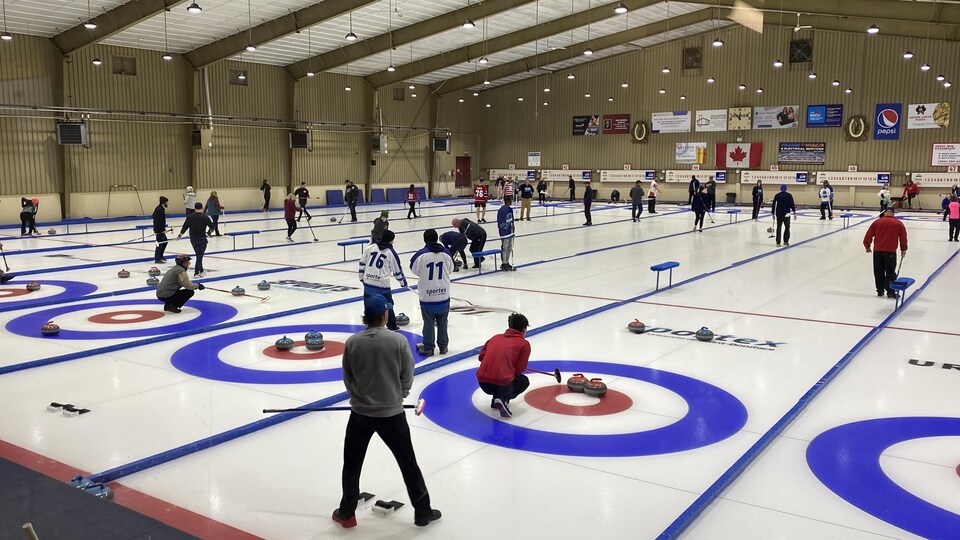 Des personnes jouent en amateur sur un terrain de curling.