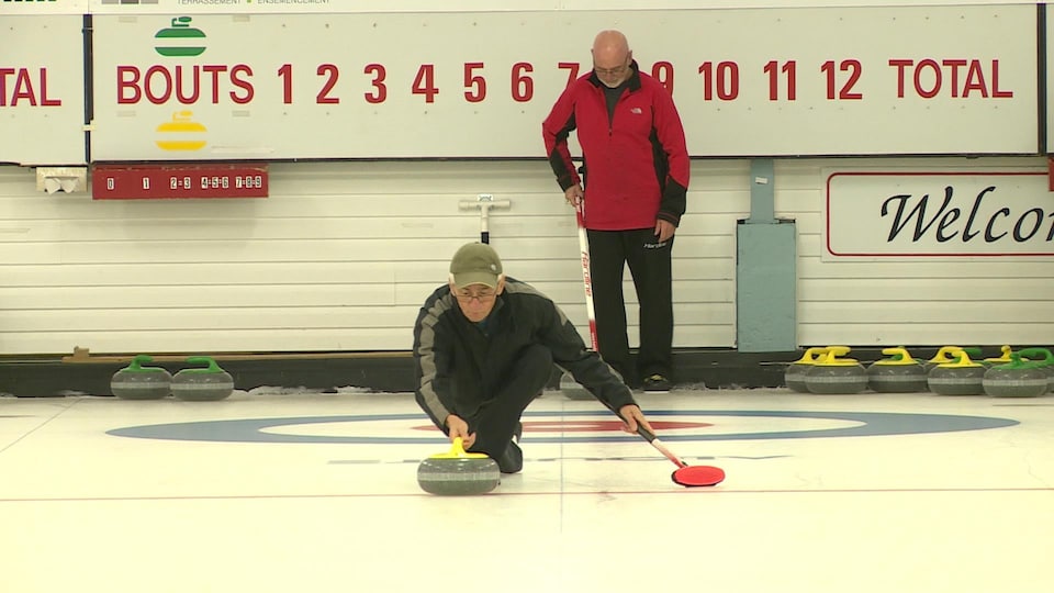 Julien Villeneuve lance une pierre de curling.