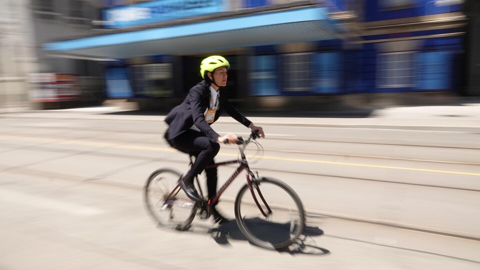 La cycliste se déplace sur une route achalandée de Toronto.