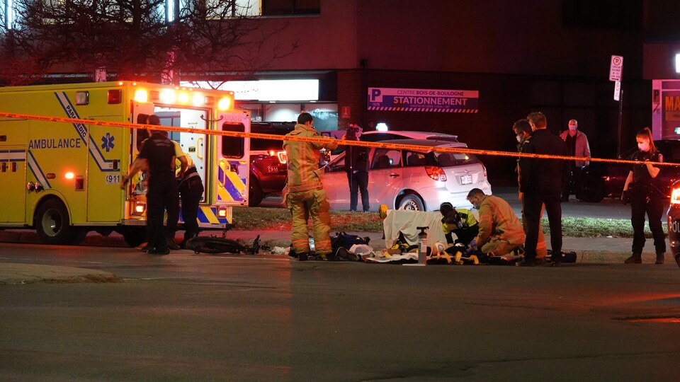 Des ambulanciers prodiguent les premiers sons au cycliste happé par une voiture.