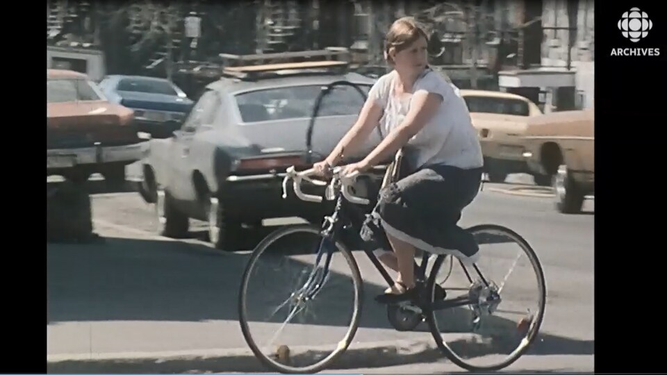 Jeune femme circulant dans les rues de Montréal en vélo dans les années 1970