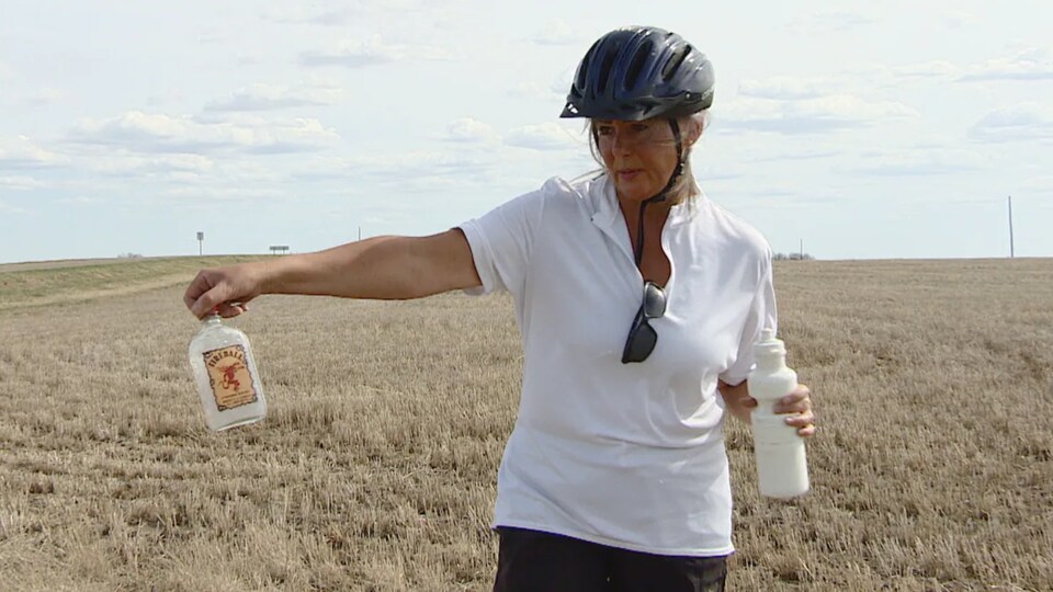 Donna Kovatch tient une bouteille d'alcool dans sa main près d'une route.