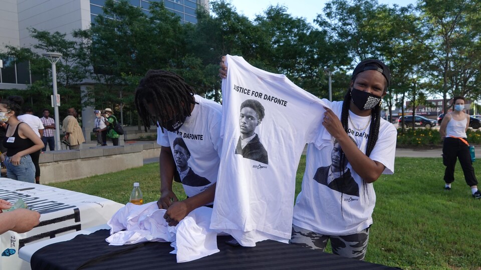 Une manifestante tient un t-shirt qui porte le message : « Que justice soit faite pour Dafonte ».