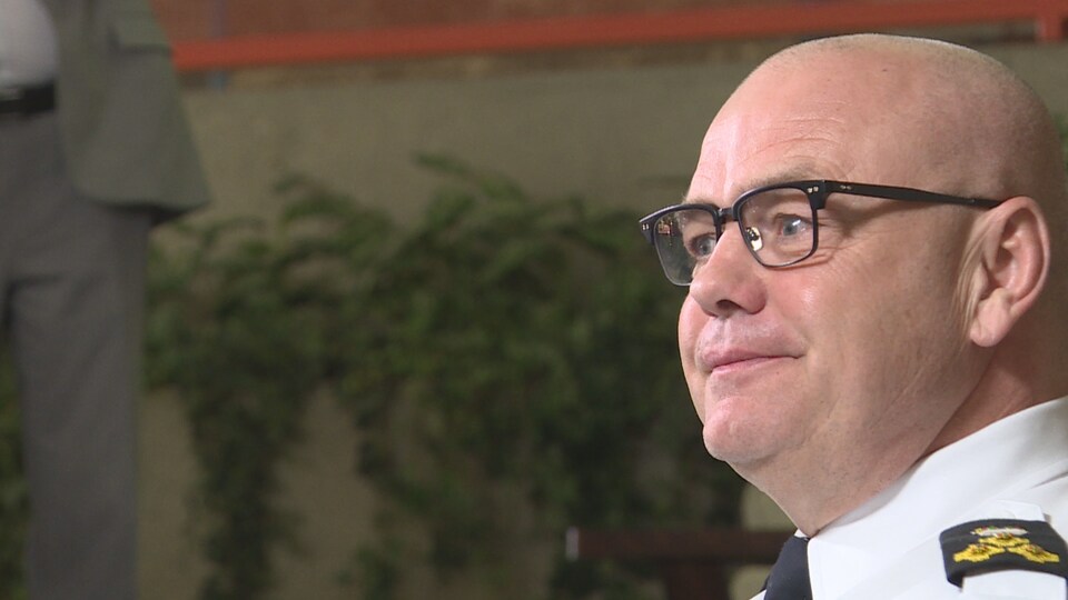 Le chef de police d'Edmonton, Dale McFee, apparaît de profil, en uniforme, dans l'atrium du quartier général des forces de l'ordre.