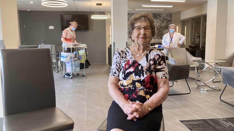 La dame âgée est assise sur une chaise et attend de recevoir le vaccin