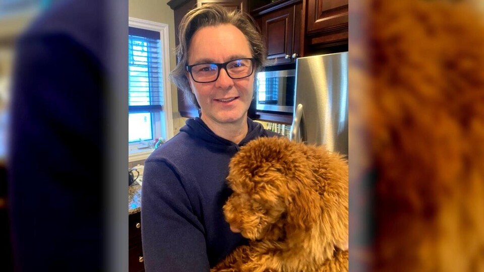Damir Stipanovic tient un chien dans une cuisine.