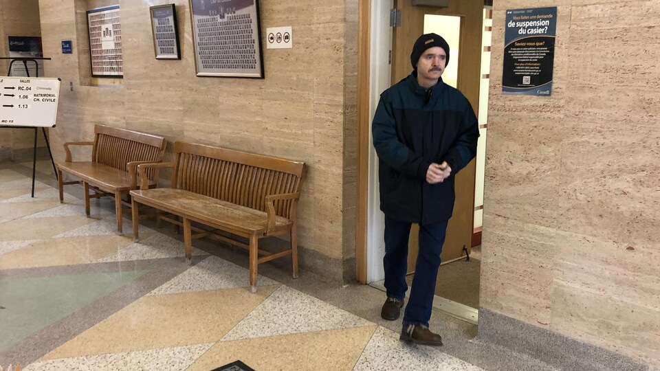 Daniel Laframboise marche dans le palais de justice.