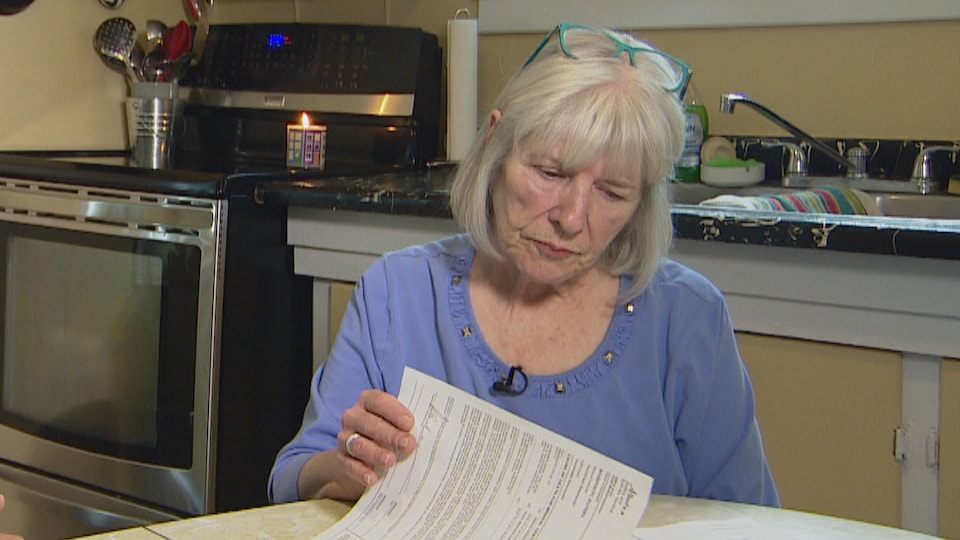 Marilyn Hayward was sitting in her kitchen, reading a document.