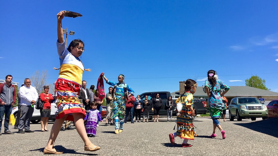 Une jeune femme danse en habit traditionnel autochtone.