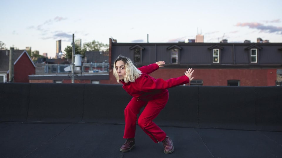 La danseuse Jessie Garon habillée en rouge sur un toit.