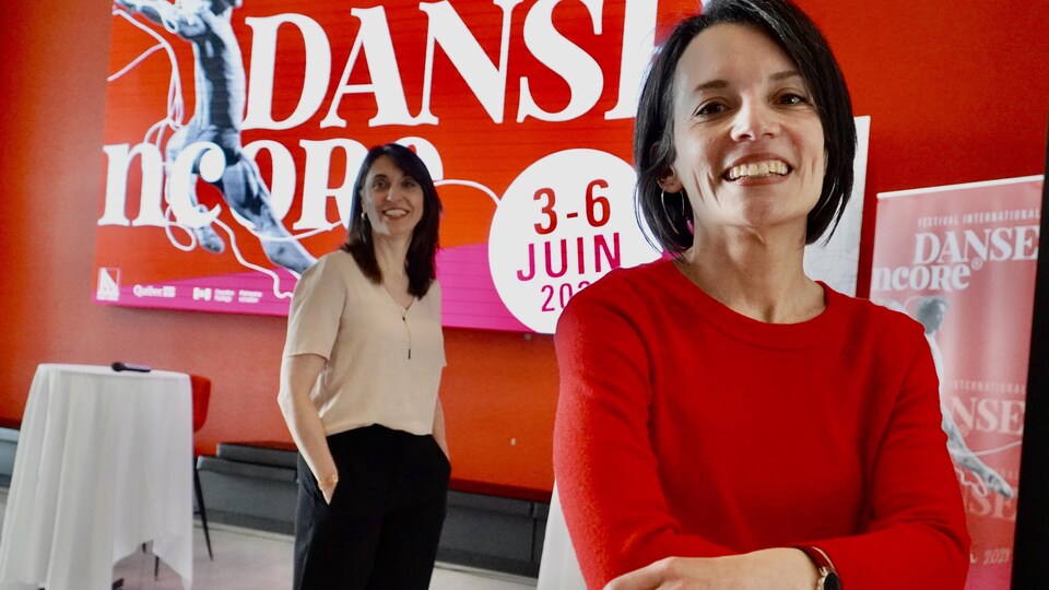 Deux femmes posent devant l'affiche du festival.