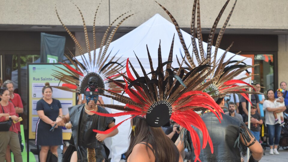À l'extérieur, des danseurs aztèques dansent devant un public.