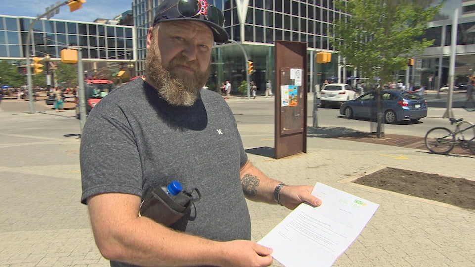 Darin Lanigan tient une lettre de la Société d’assurance du gouvernement de la Saskatchewan (SGI).