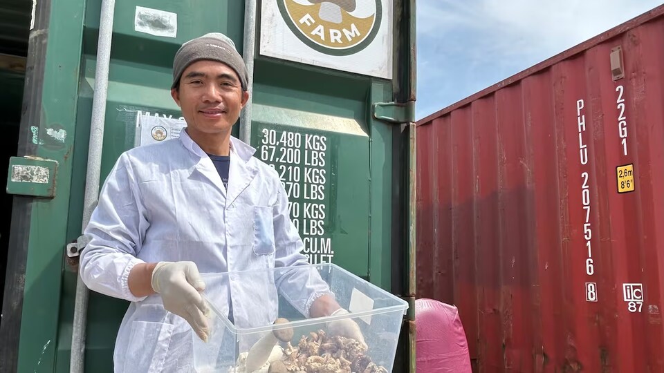 Darren Tran devant conteneur. 