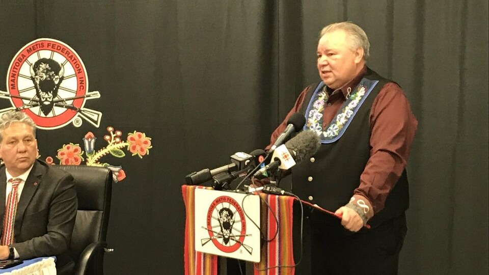 Un homme se tient à un podium dans le cadre d'une conférence de presse.
