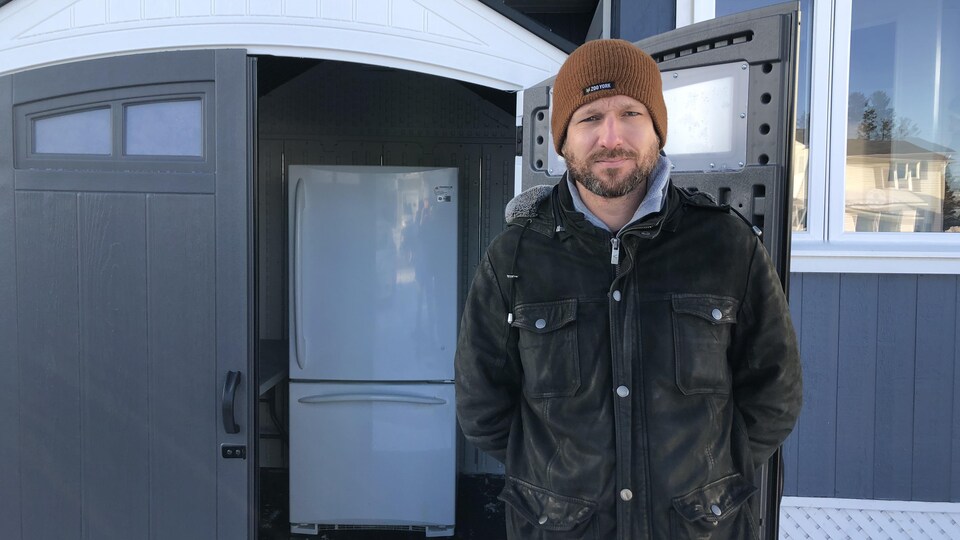 Le directeur de Transit Sept-Îles devant le nouveau frigo. 