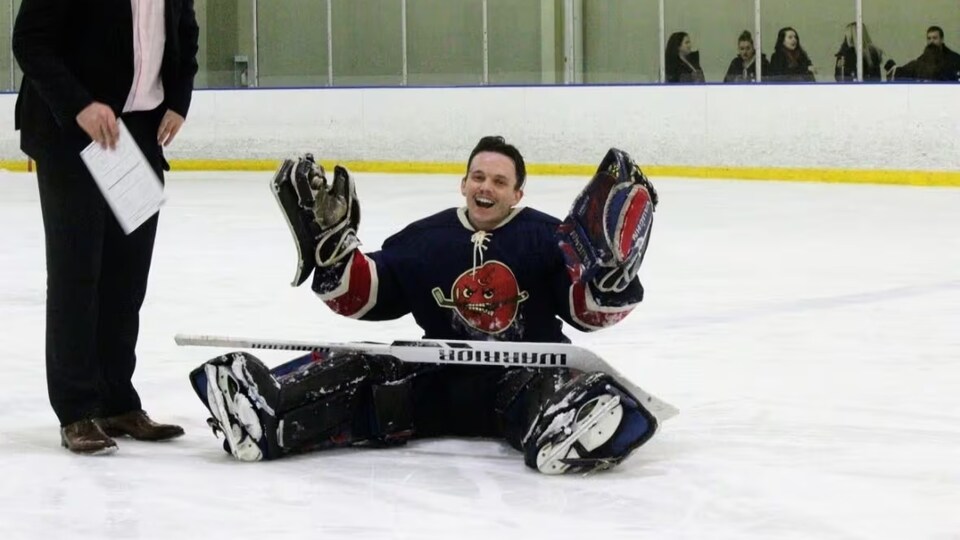 Le joueur est assis sur la glace.