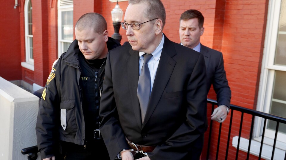 David Lee Poulson, au centre, un prêtre catholique romain qui a plaidé coupable d'avoir agressé sexuellement deux garçons, sort du tribunal menotté après avoir été condamné le vendredi 11 janvier 2019 à Brookville.