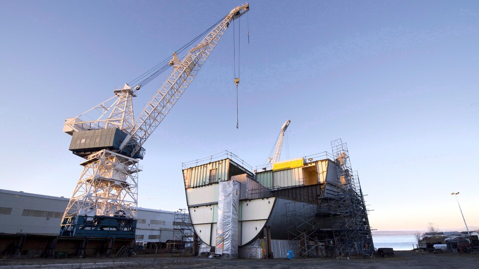 Une grue près de la carcasse d'un bateau