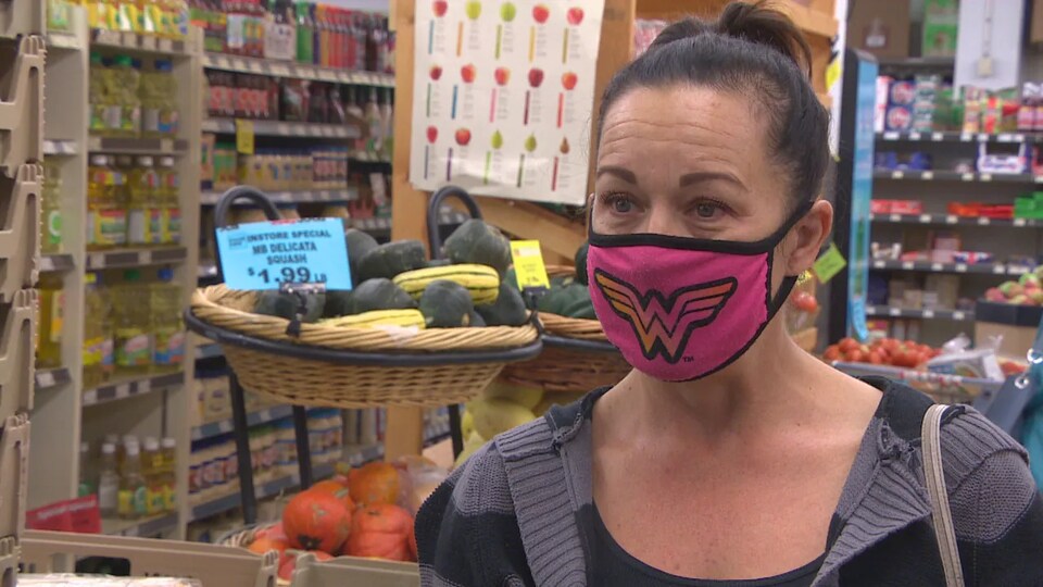 Deanna Migalski est interrogée dans une épicerie. Elle porte un masque.