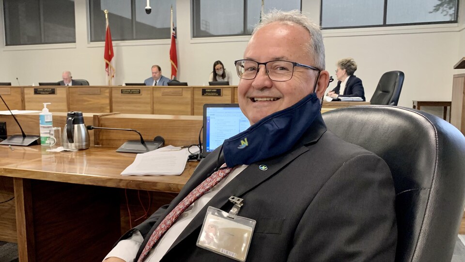 François St-Amour, bien assis, fait un grand sourire à la caméra.