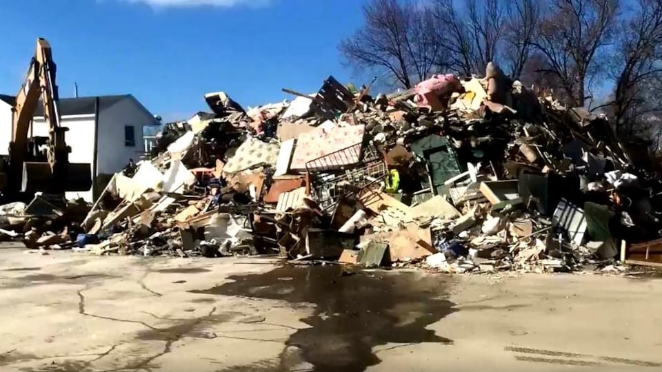 Une pelle mécanique empile des déchets de toutes sortes à Sainte-Marie, en Beauce.