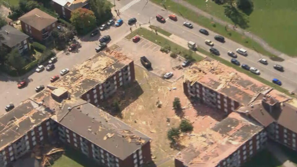 Des immeubles touchés par la tornade survenue vendredi. Les toits des édifices sont endommagés.