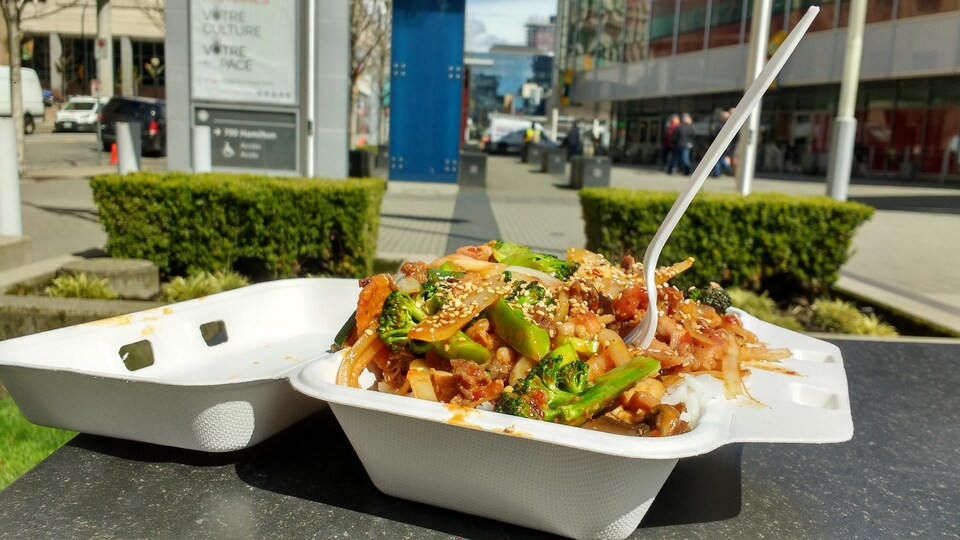 Un repas chaud dans un contenant jetable sur une table extérieure à Vancouver